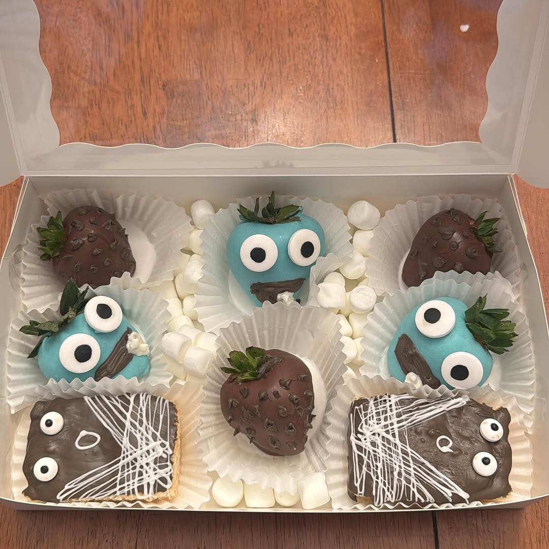 Cookie Monster-themed treat box with teal blue googly-eyed strawberries and monster-face Rice Krispie bars with mini marshmallows.