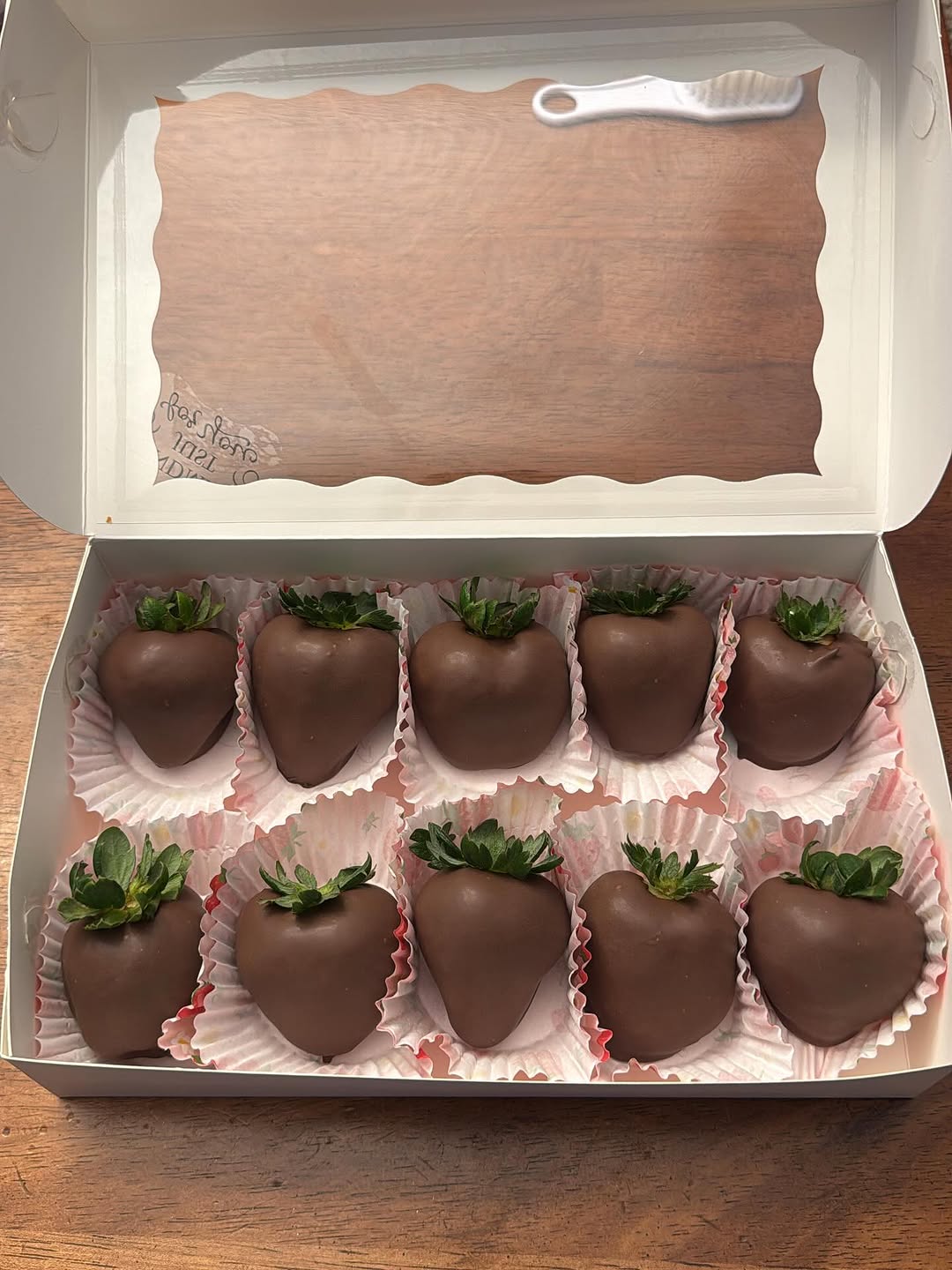 Nine classic smooth milk chocolate-covered strawberries with no embellishments, the purest traditional presentation in pink pastel paper liners.