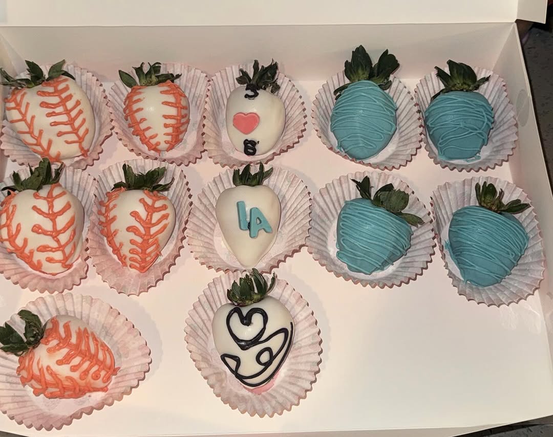 LA Dodgers baseball-themed chocolate strawberries with white coatings, orange baseball stitching, blue LA lettering, and pink heart designs.